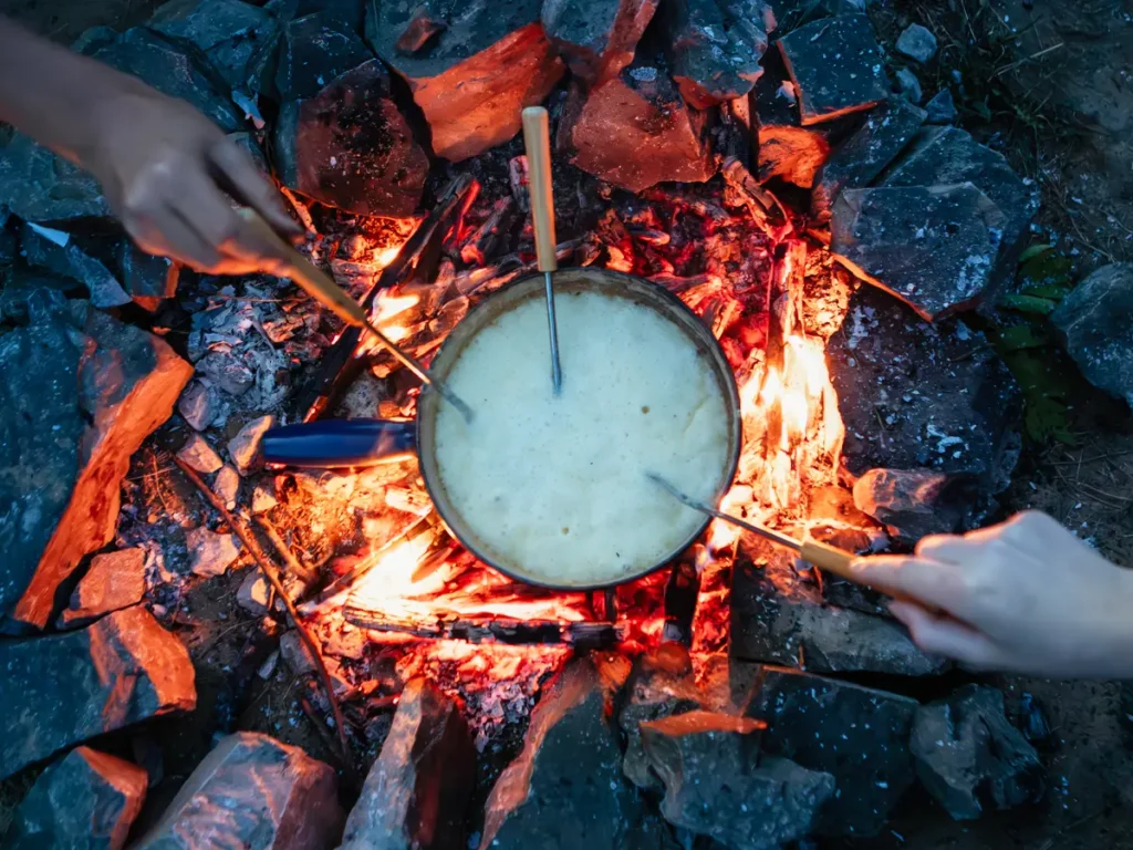 Caquelon rempli de fondue au fromage en camping